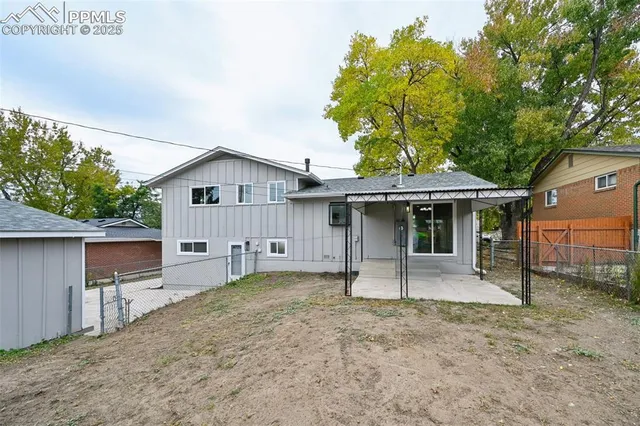 a view of a house with a yard and large tree