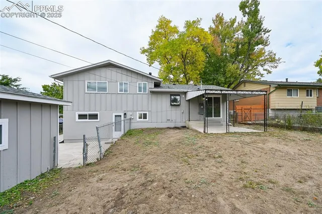 a white house with a large tree in front of it
