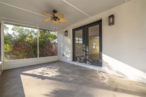 a view of a big room with windows and ceiling fan