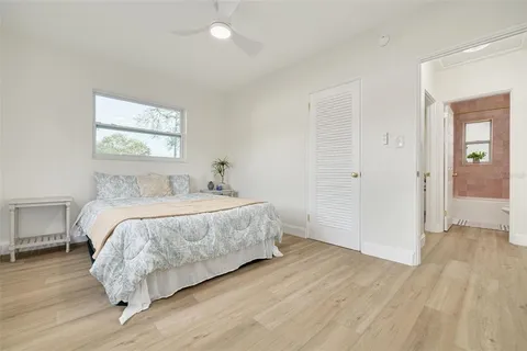 a bed sitting in a spacious bedroom next to a window