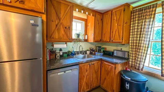 a kitchen with stainless steel appliances granite countertop a refrigerator and a sink
