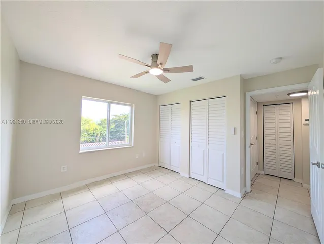 an empty room with closet and windows