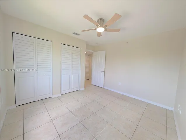 an empty room with closet and fan