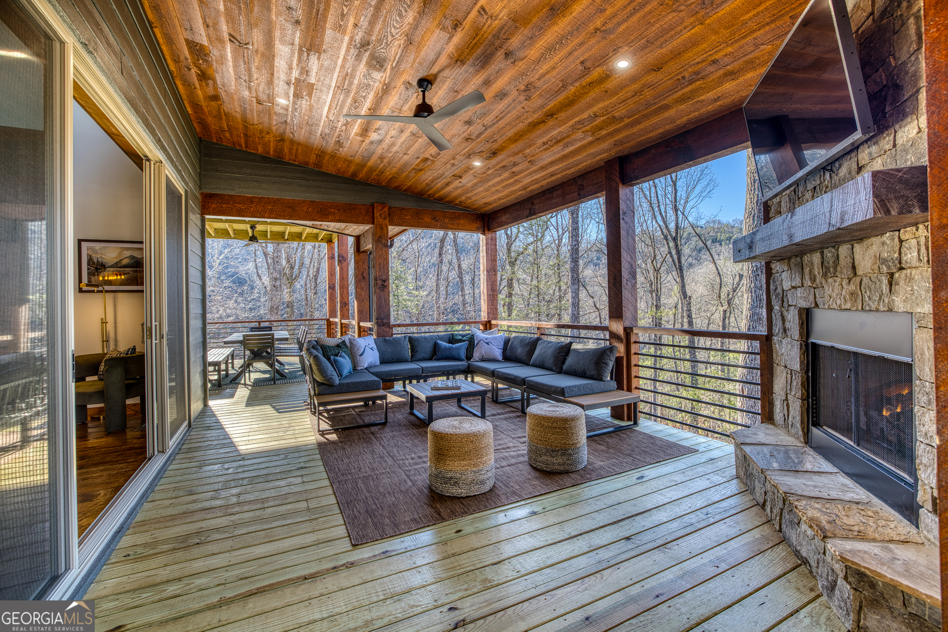 1160 Mangum's Trail Blue Ridge, GA 30513 - Photo 65 of 75 a view of a patio with table and chairs couches with wooden floor and fence