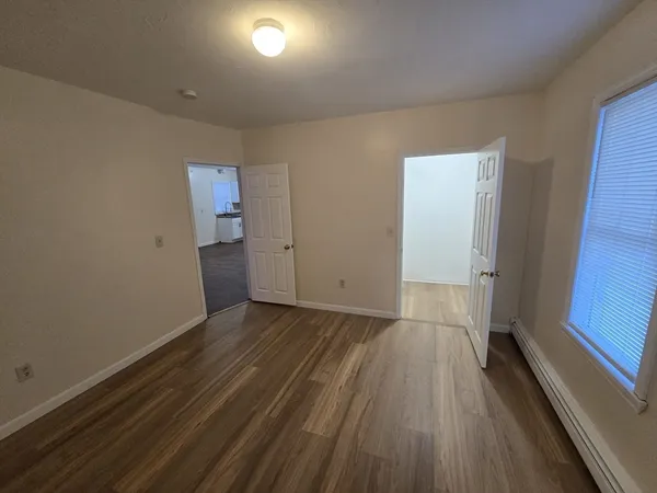 a view of an empty room with wooden floor