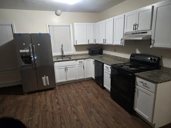a kitchen with stainless steel appliances granite countertop a refrigerator and a stove top oven