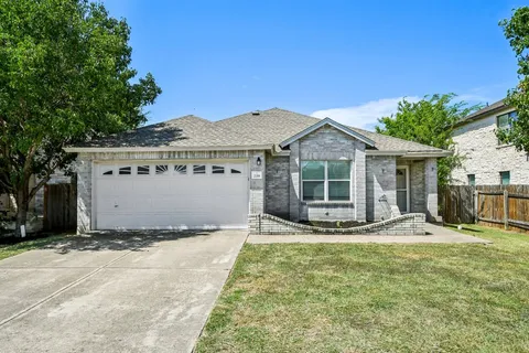 a view of a house with a yard and large tree
