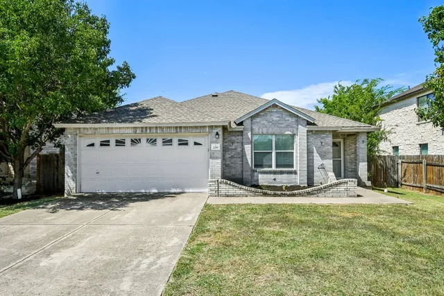a view of a house with a yard and large tree