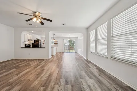a view of a kitchen with wooden floor and a ceiling fan
