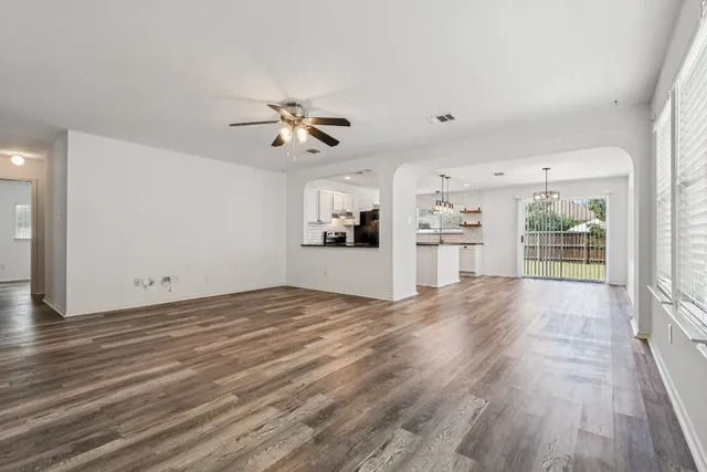 a view of a kitchen with wooden floor and a kitchen space with a sink