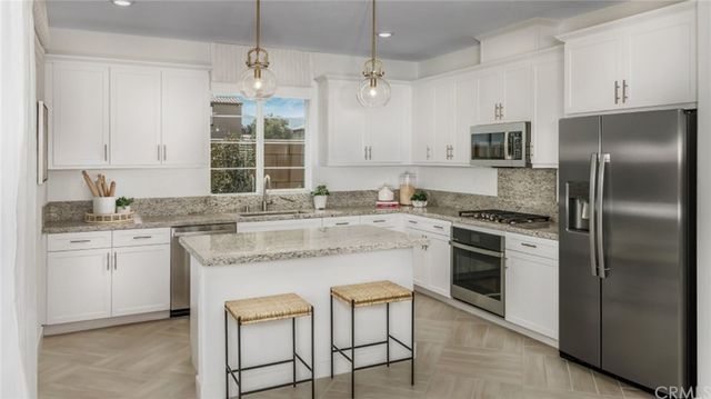 a kitchen with a stove refrigerator sink and microwave