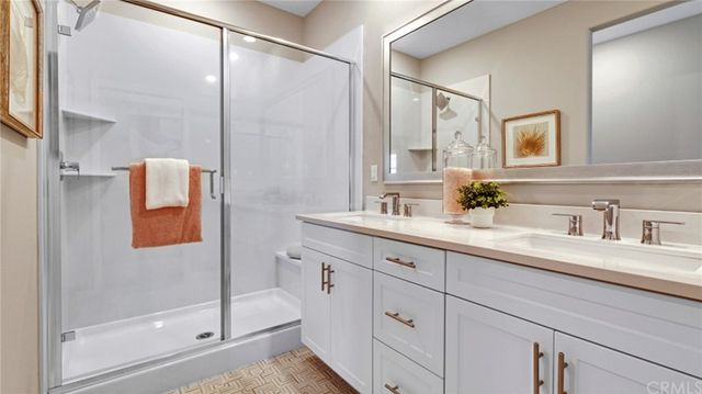 a bathroom with a double vanity sink mirror and shower
