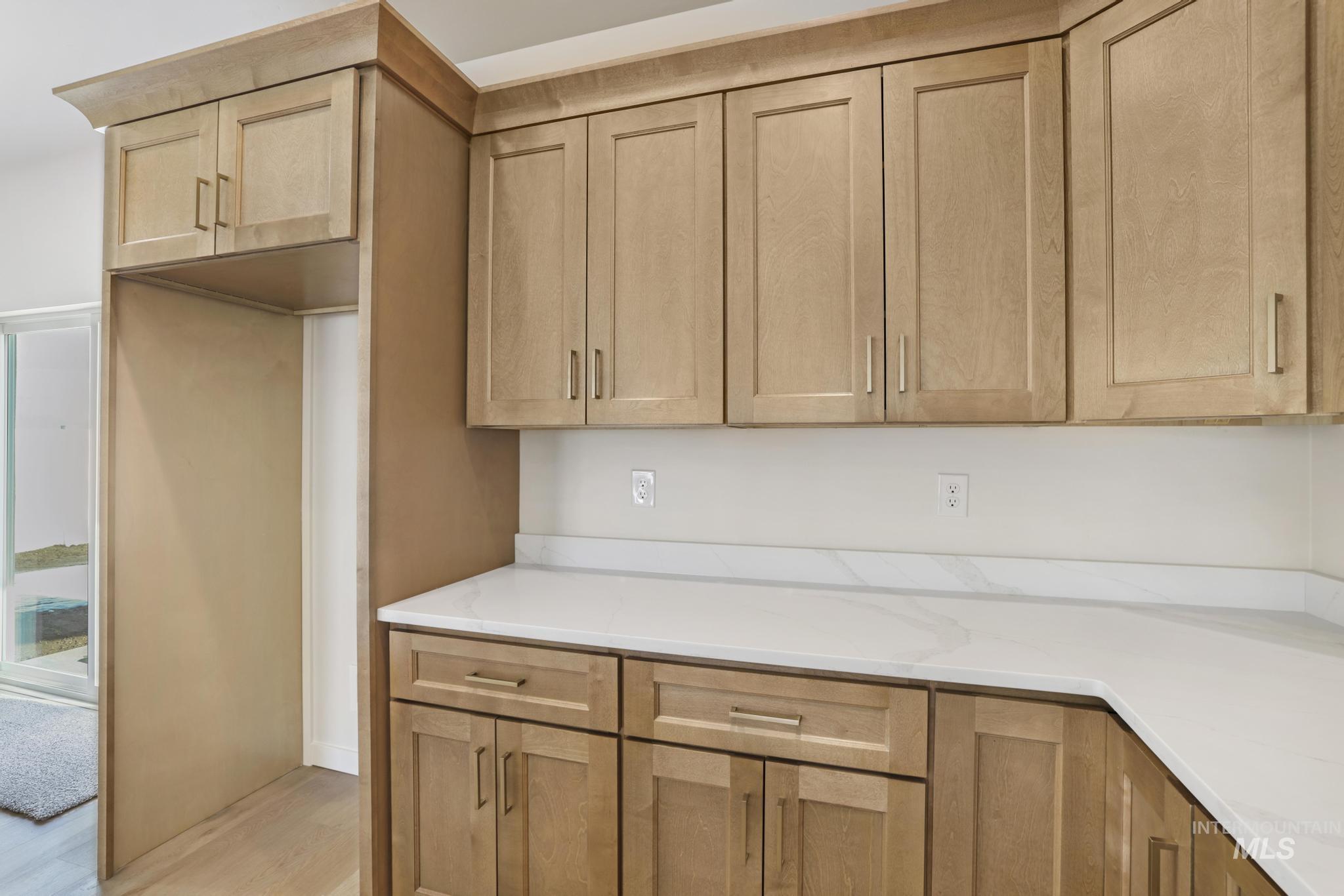 2014 Regan Street Jerome, ID 83338 - Photo 12 of 32 Kitchen with light stone countertops, light wood-type flooring, and light brown cabinets