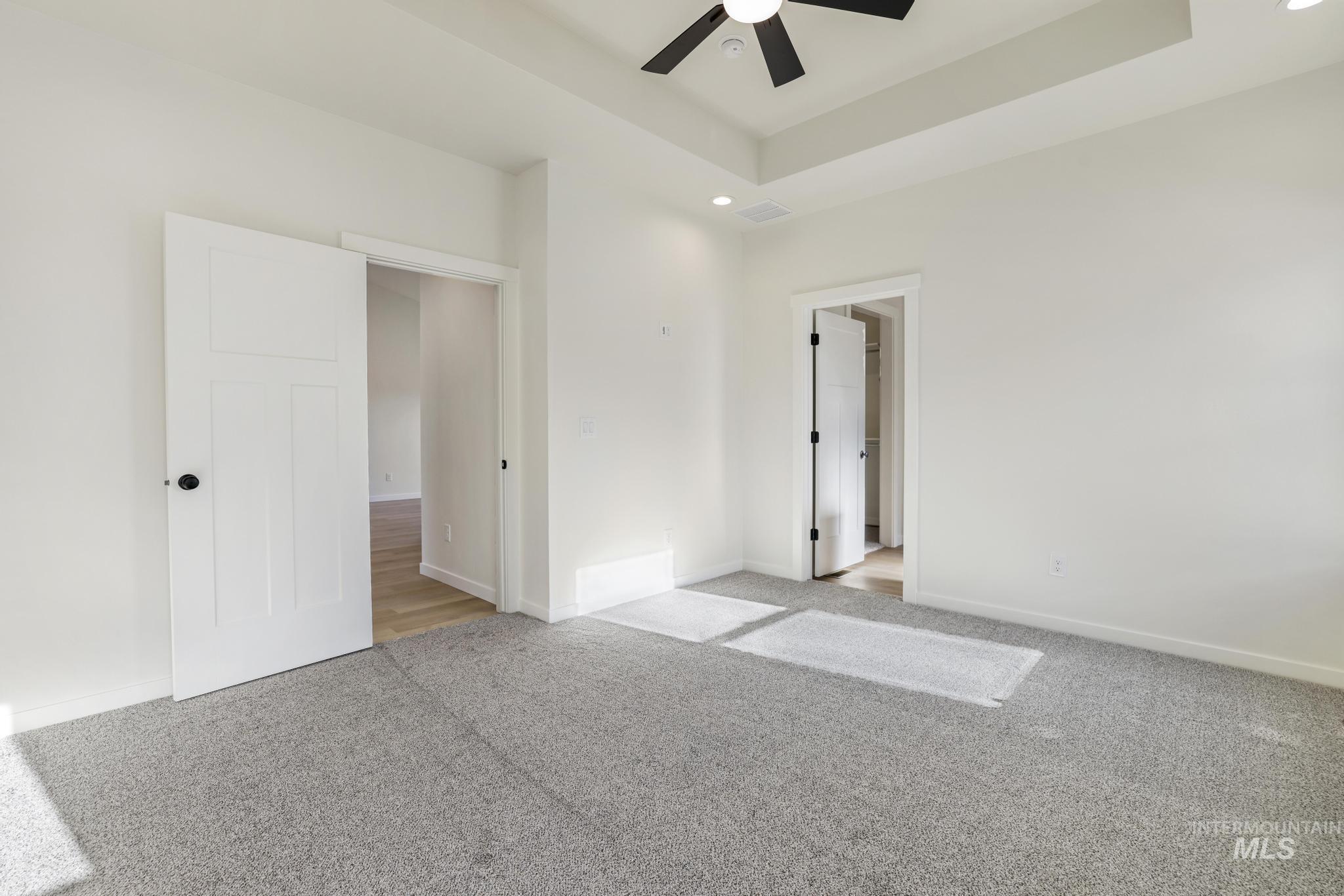 2014 Regan Street Jerome, ID 83338 - Photo 15 of 32 Master bedroom with carpet, a tray ceiling, recessed lighting, and a ceiling fan