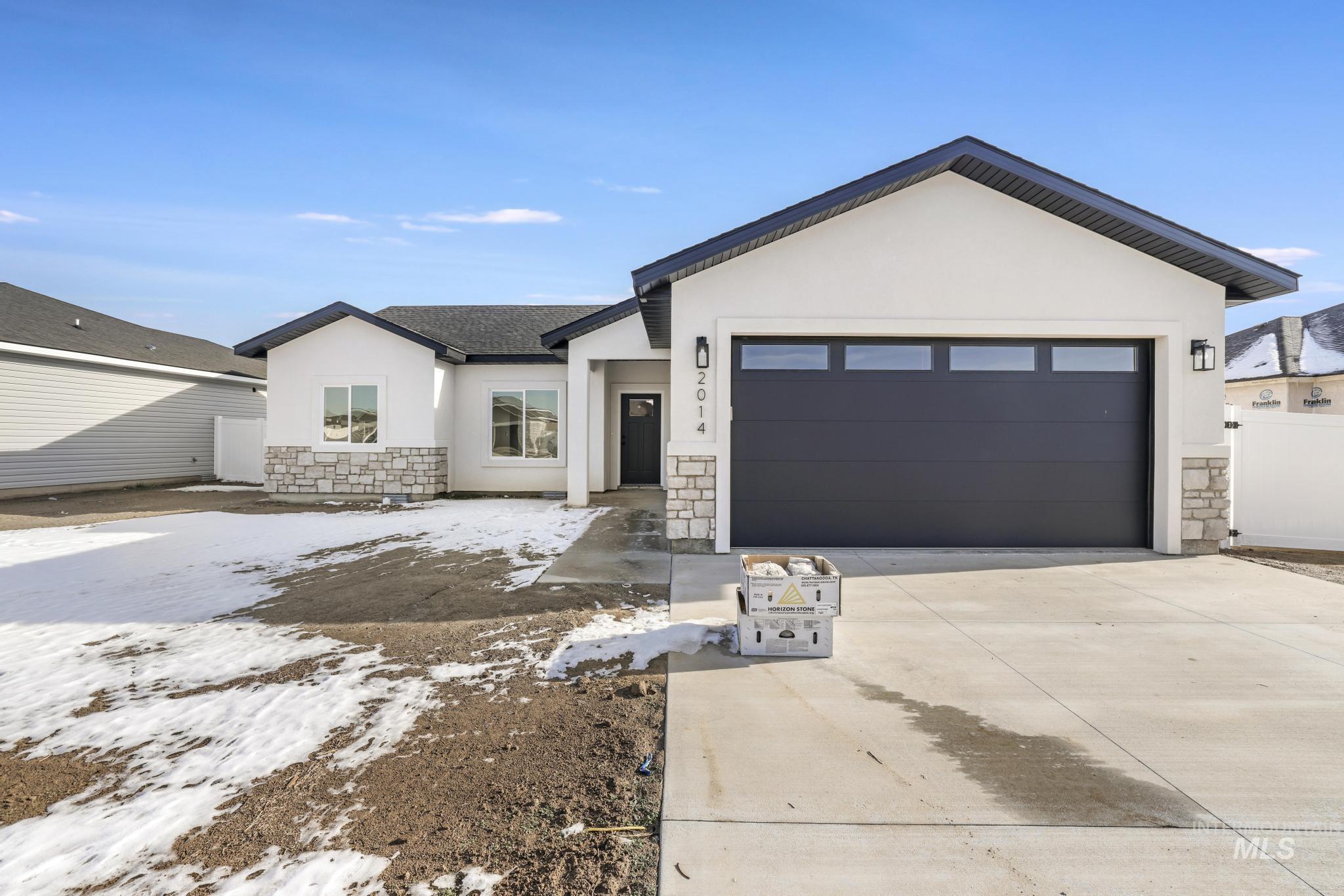 2014 Regan Street Jerome, ID 83338 - Photo 2 of 32 View of front facade with stone siding, stucco siding, concrete driveway, a garage, and roof with shingles