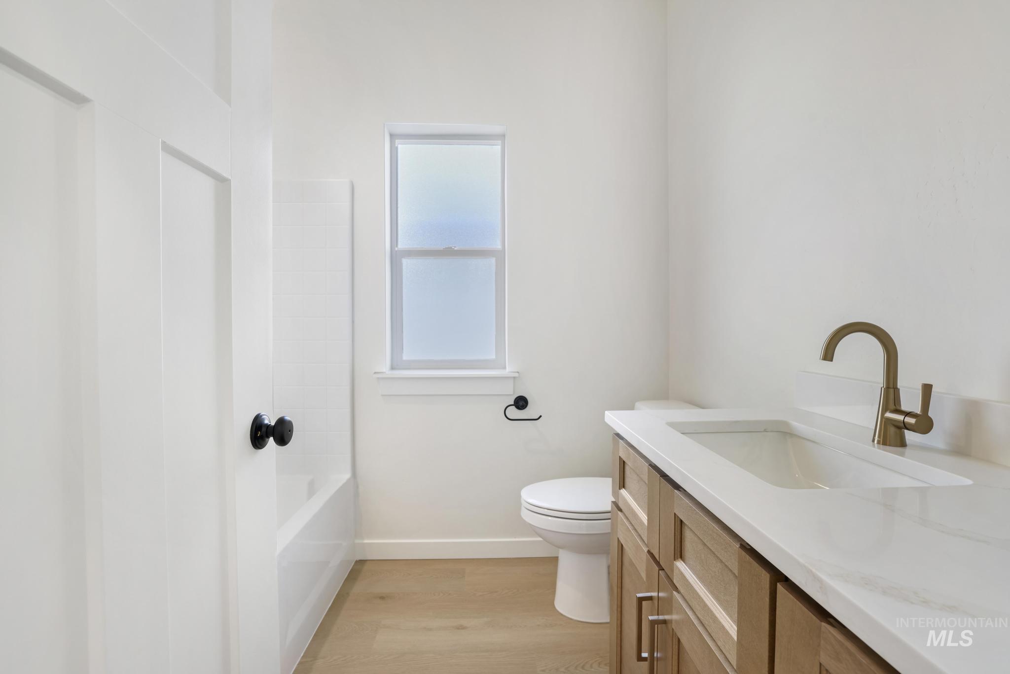 2014 Regan Street Jerome, ID 83338 - Photo 20 of 32 Bathroom with vanity, light wood-type flooring, and shower / washtub combination