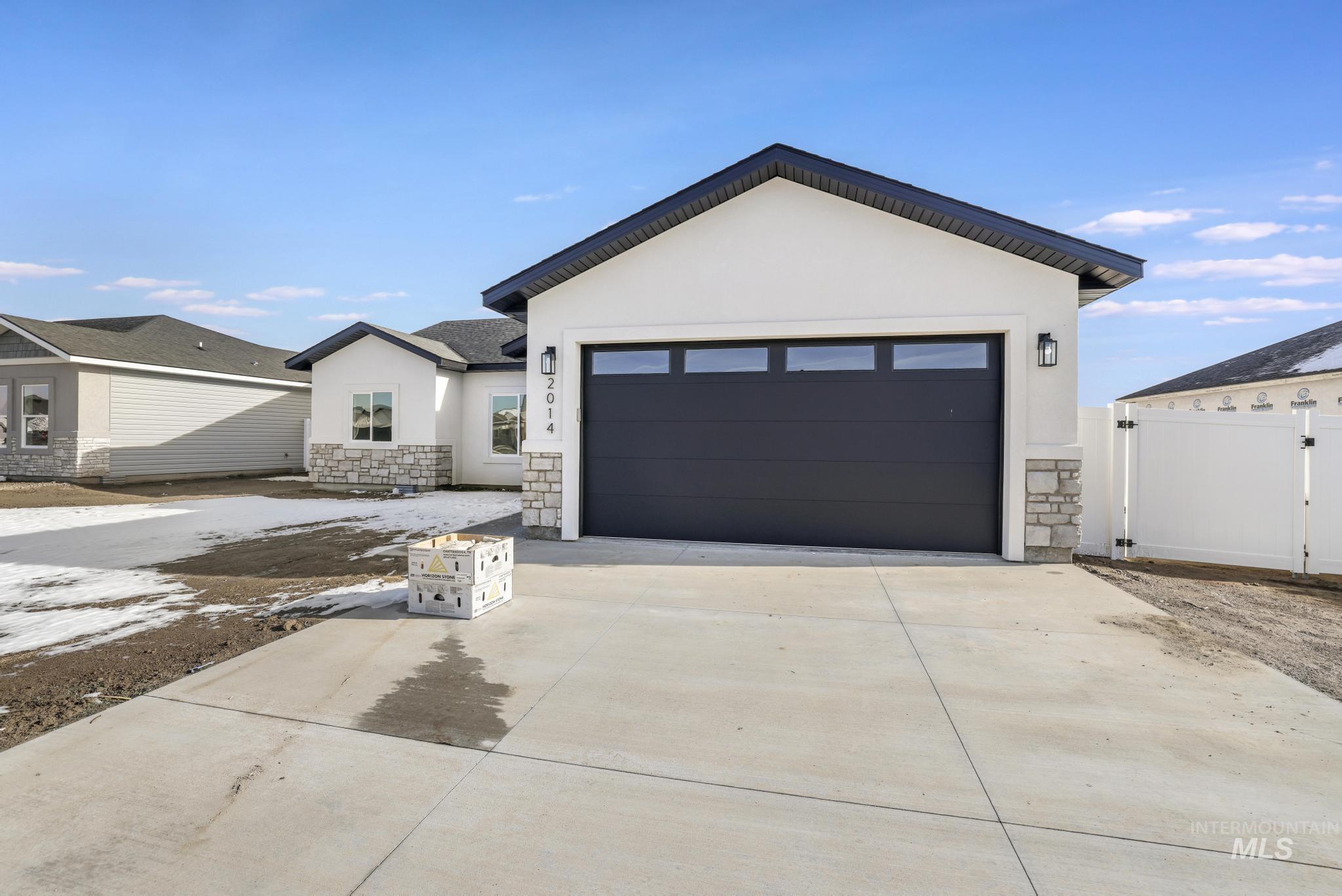 2014 Regan Street Jerome, ID 83338 - Photo 3 of 32 View of front of property featuring stone siding, concrete driveway, and stucco siding
