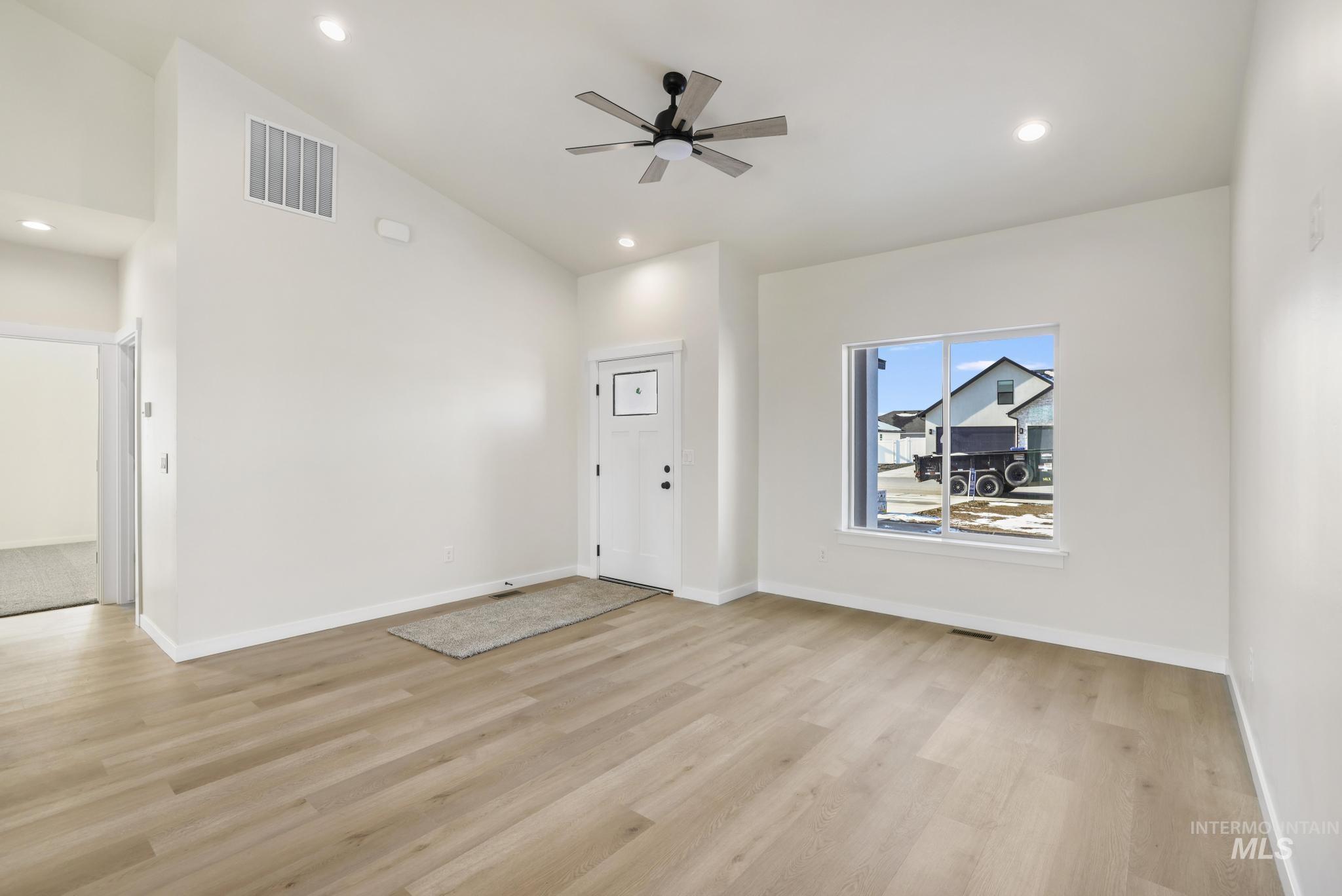 2014 Regan Street Jerome, ID 83338 - Photo 6 of 32 Unfurnished living room with a ceiling fan, light wood-style floors, high vaulted ceiling, and recessed lighting