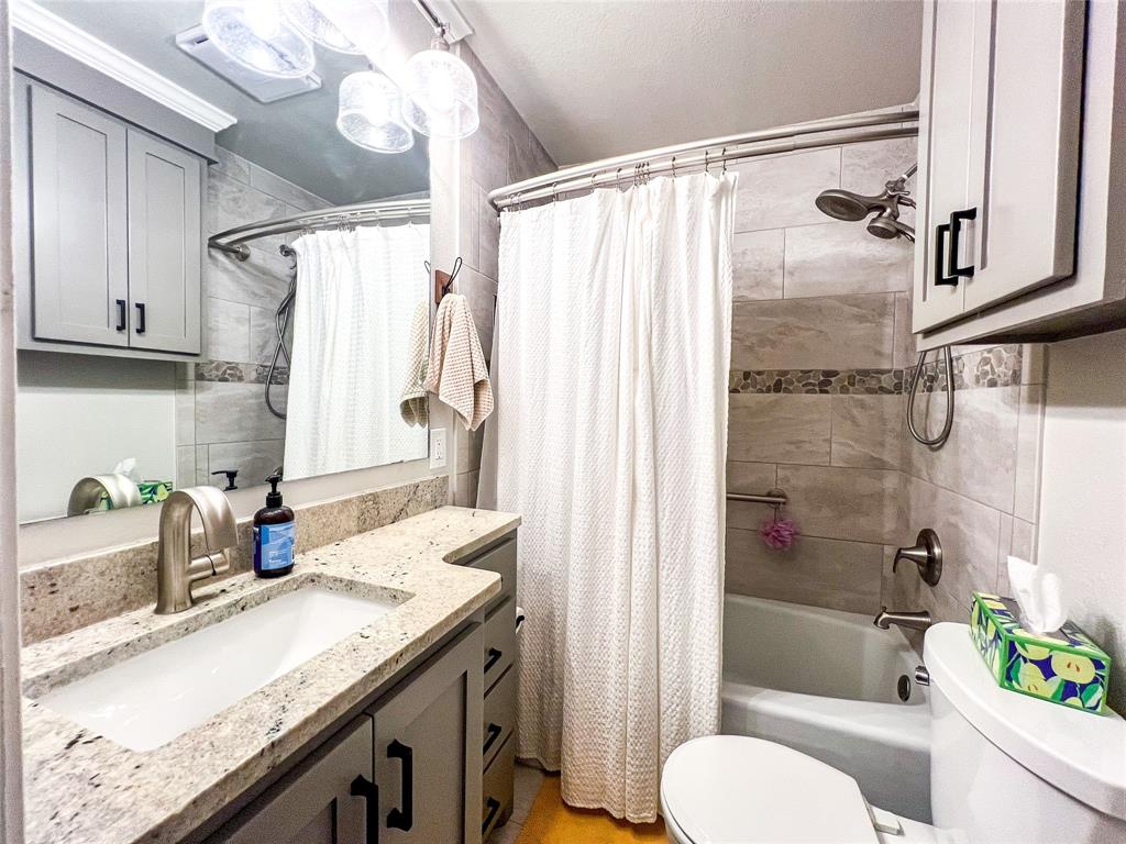 1009 North 7th Street Haskell, TX 79521 - Photo 13 of 26 a bathroom with a granite countertop sink toilet and shower