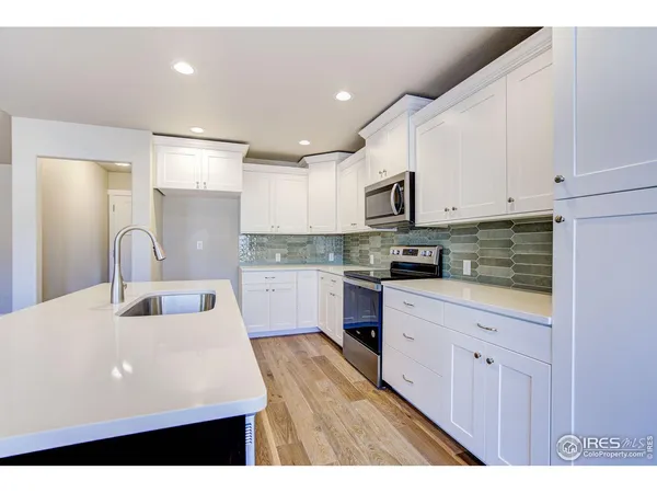 a kitchen with stainless steel appliances a refrigerator sink and cabinets