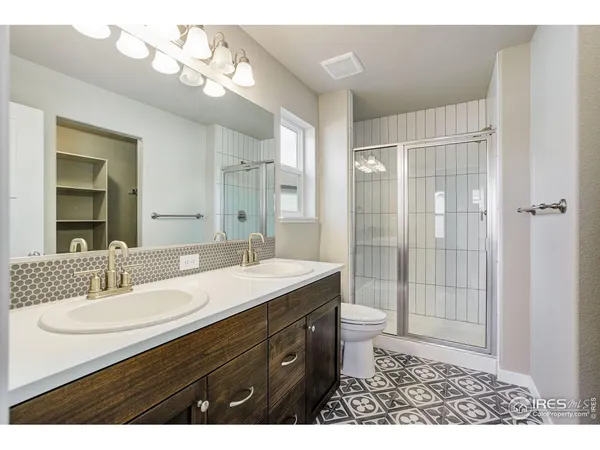 a bathroom with a double vanity sink mirror and toilet