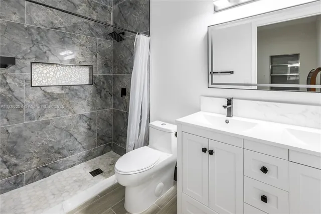 a bathroom with a sink a toilet and shower