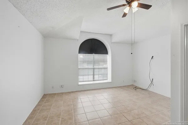 an empty room with windows and fan