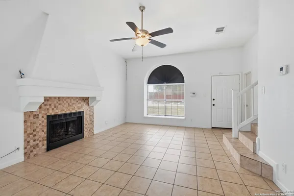 a view of an empty room with a fireplace and a window
