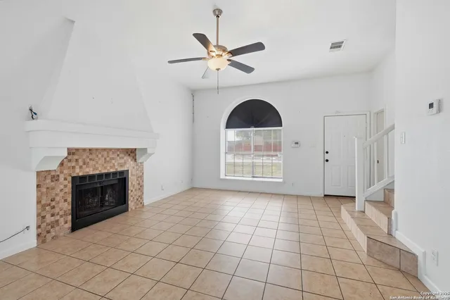 a view of an empty room with a fireplace and a window