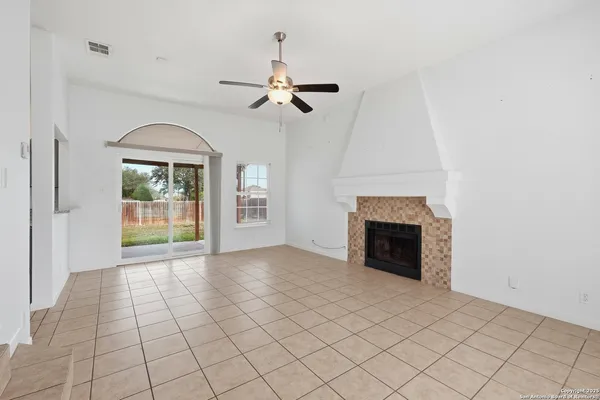 an empty room with windows and fireplace