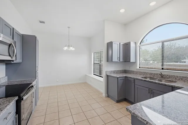 a kitchen with stainless steel appliances granite countertop a sink and a stove