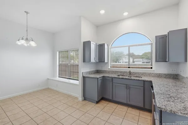 a large kitchen with granite countertop a sink and a stove