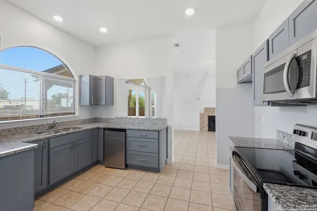 a kitchen with stainless steel appliances granite countertop a sink and a stove