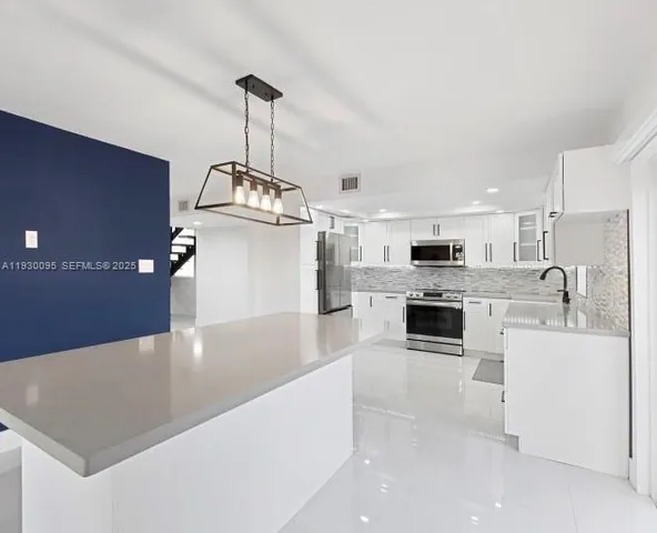 a kitchen with stainless steel appliances granite countertop a refrigerator sink and stove