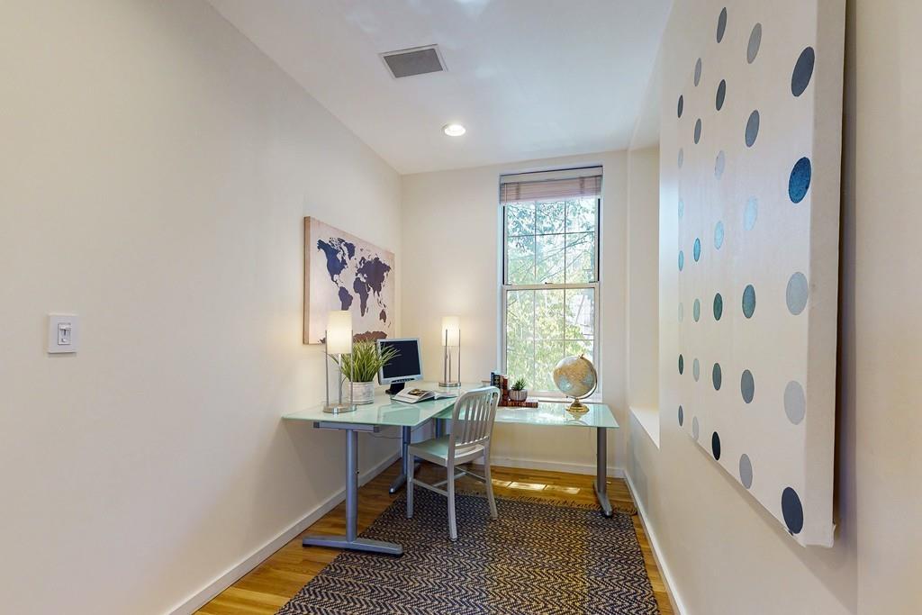 169-171 West 2nd Street Boston, MA 02127 - Photo 6 of 20 a workspace with wooden floor and a chandelier