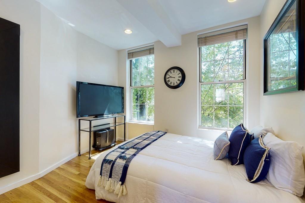 169-171 West 2nd Street Boston, MA 02127 - Photo 7 of 20 a bedroom with a bed and a flat screen tv