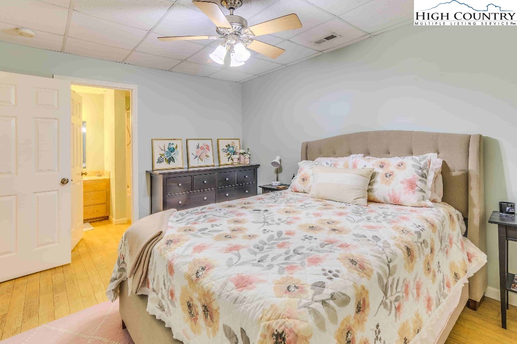 169 Violet Lane Boone, NC 28607 - Photo 18 of 27 a spacious bedroom with a bed and a chandelier