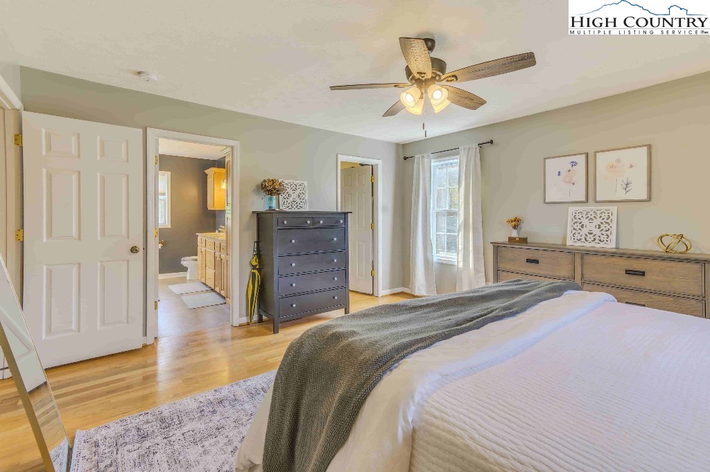 169 Violet Lane Boone, NC 28607 - Photo 4 of 27 a spacious bedroom with a bed and a chandelier