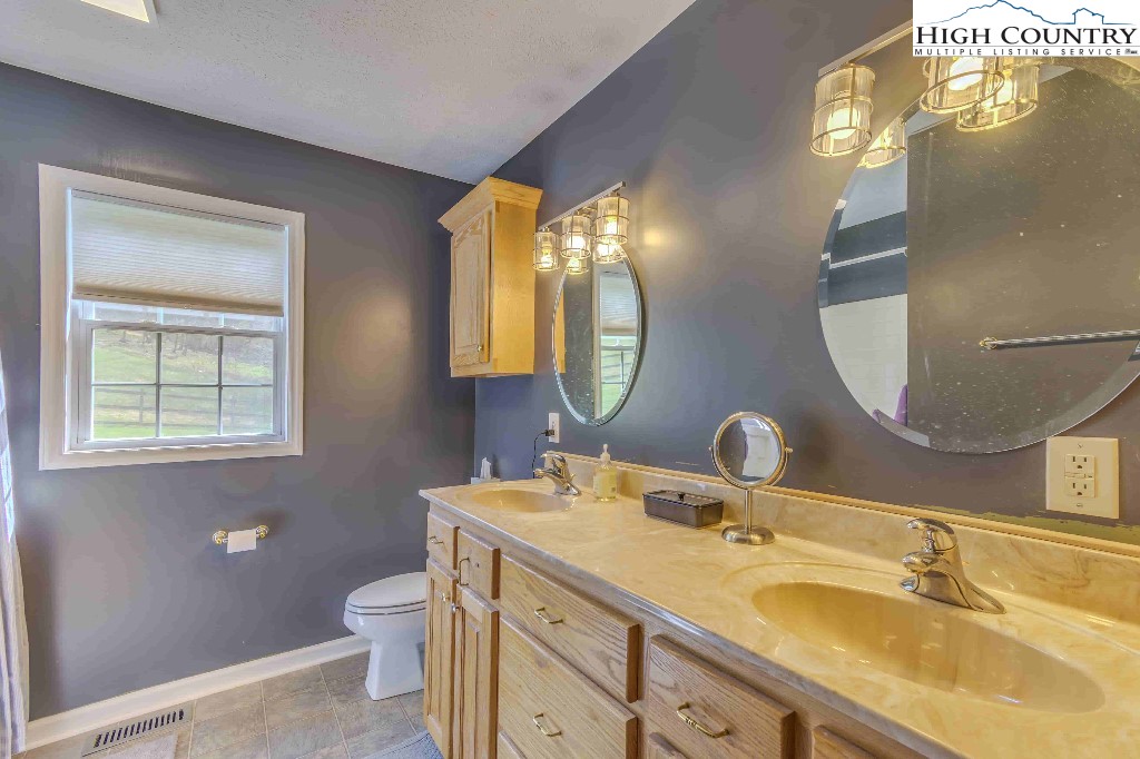 169 Violet Lane Boone, NC 28607 - Photo 5 of 27 a bathroom with a double vanity sink and a mirror
