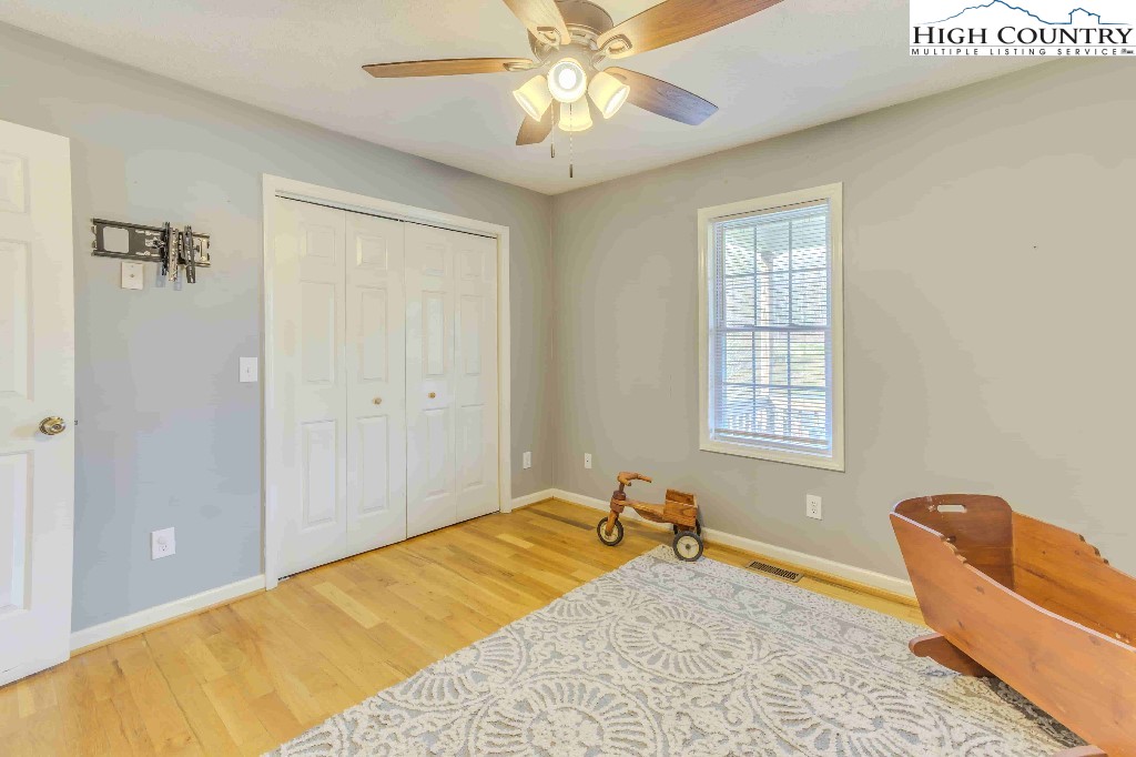 169 Violet Lane Boone, NC 28607 - Photo 8 of 27 a bedroom with a bed and a chandelier