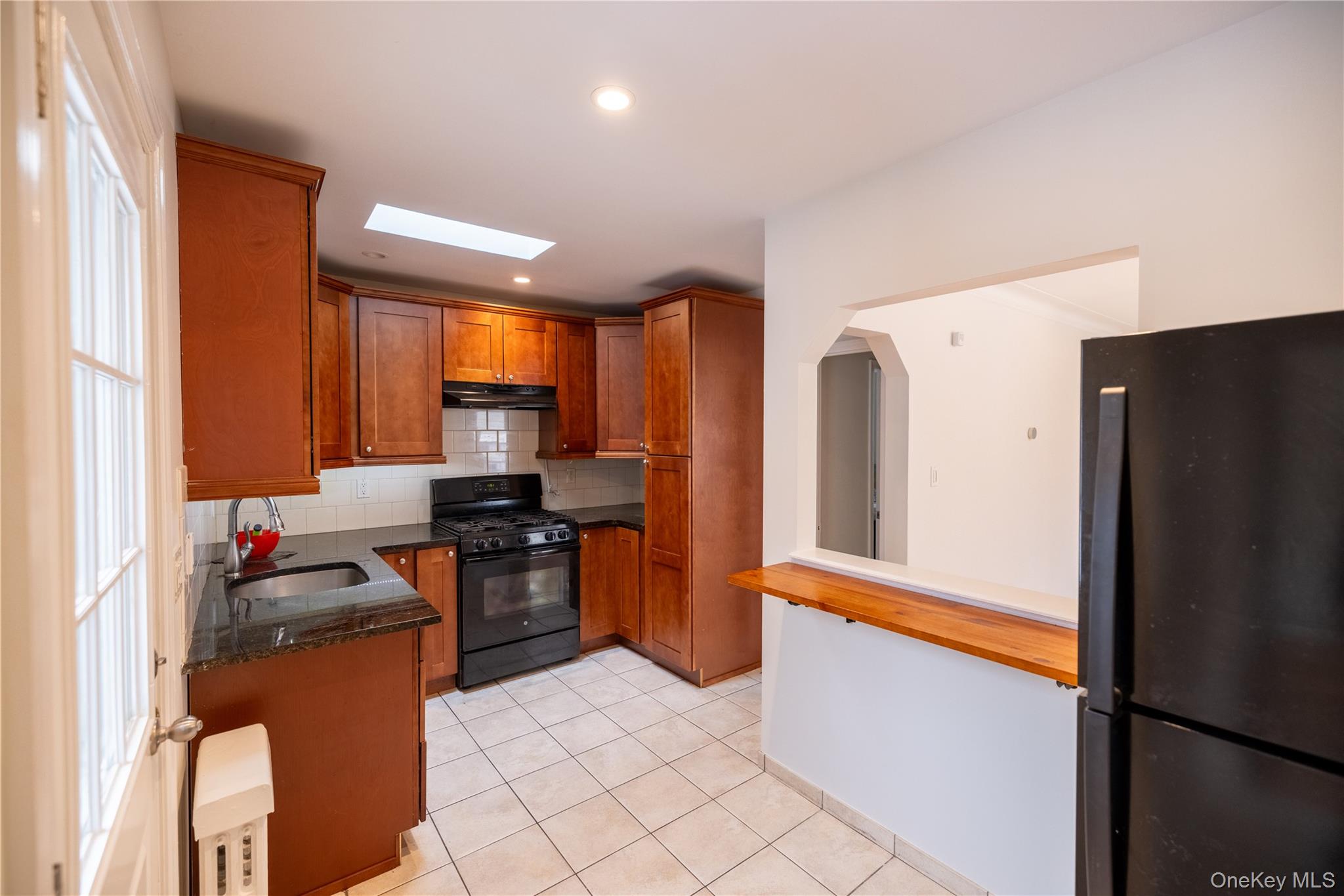 a kitchen with stainless steel appliances granite countertop a refrigerator and a stove