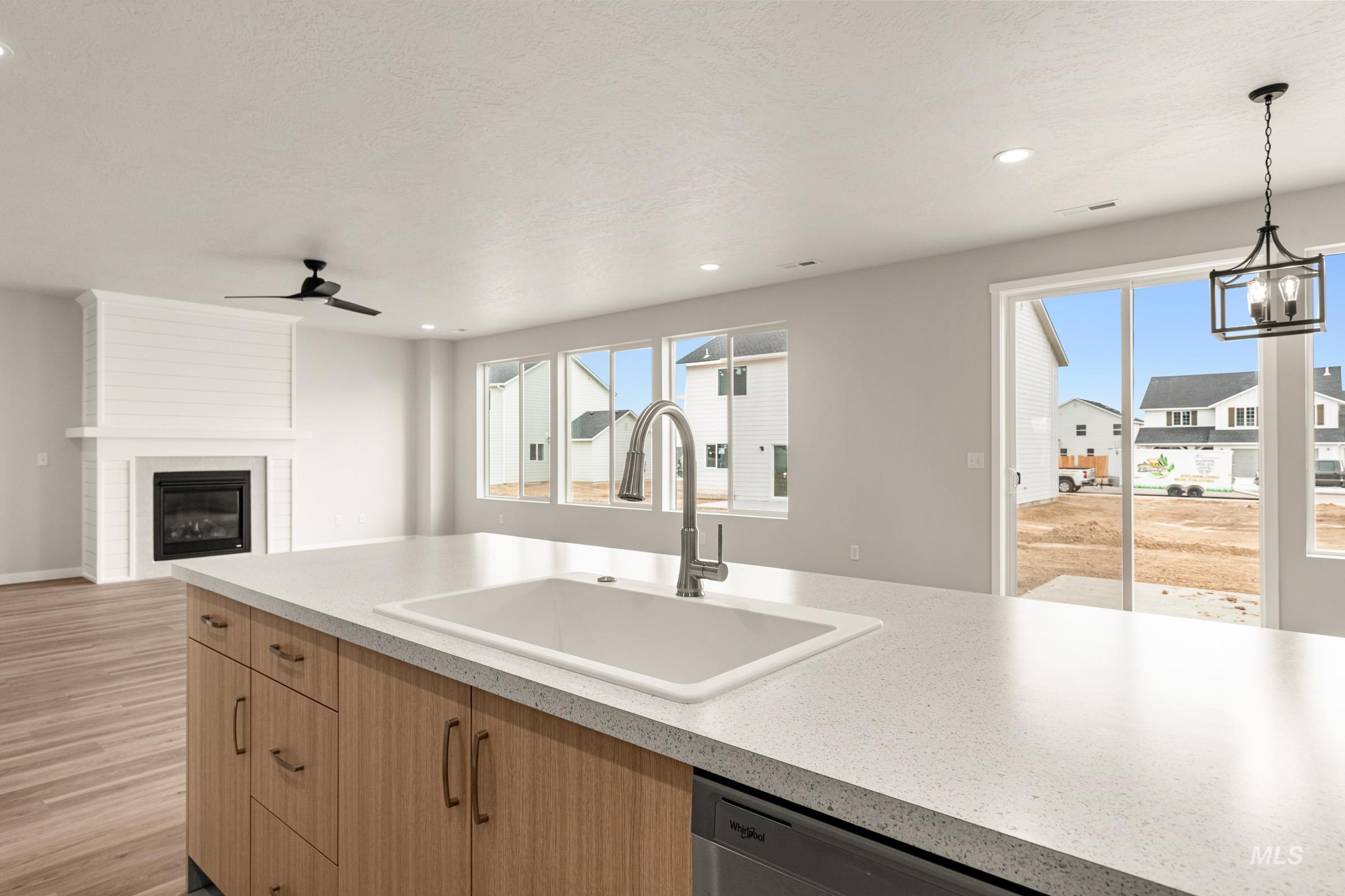 13688 Redway Court Caldwell, ID 83607 - Photo 25 of 26 Kitchen featuring a fireplace, light countertops, open floor plan, stainless steel dishwasher, and light wood-style floors