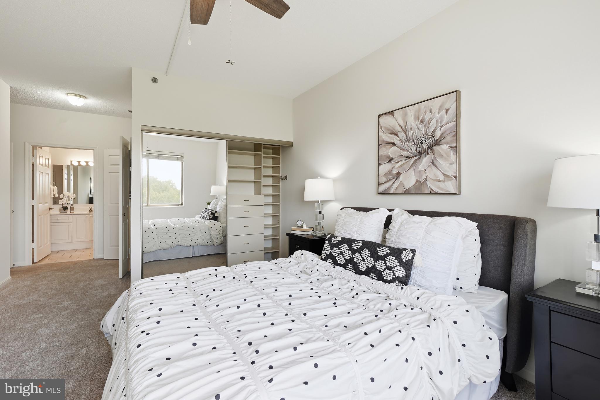 3210 North Leisure World Boulevard, Unit 1001 Silver Spring, MD 20906 - Photo 15 of 58 a bedroom with a large bed and a chandelier