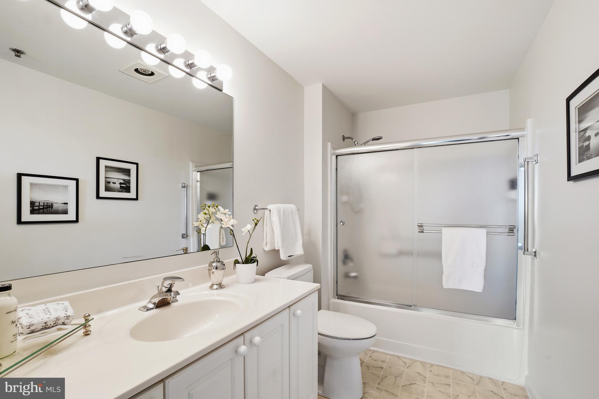 3210 North Leisure World Boulevard, Unit 1001 Silver Spring, MD 20906 - Photo 23 of 58 a bathroom with a sink vanity granite toilet and shower