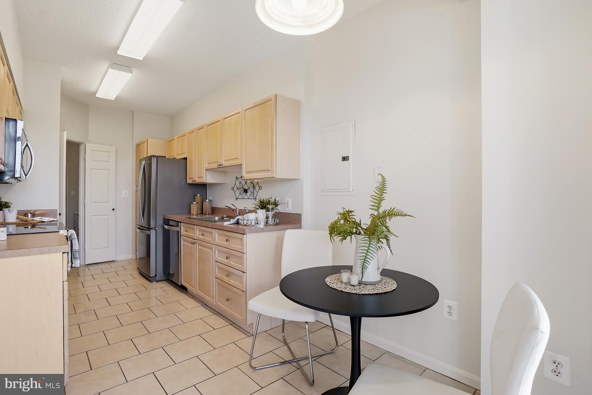 3210 North Leisure World Boulevard, Unit 1001 Silver Spring, MD 20906 - Photo 10 of 58 a kitchen with stainless steel appliances a sink and a refrigerator