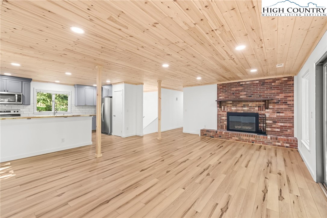 219 Hillandale Drive Boone, NC 28607 - Photo 10 of 33 a view of an empty room with wooden floor and a kitchen