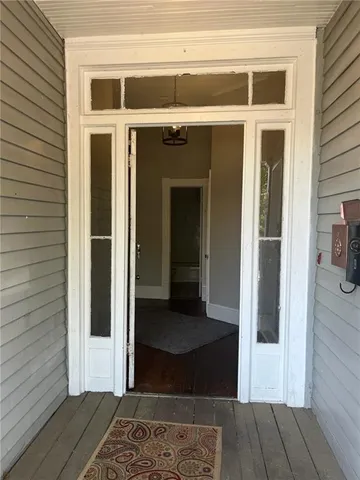 a view of a hallway with wooden floor and a living room