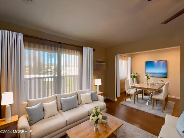 a living room with furniture wooden floor and a large window