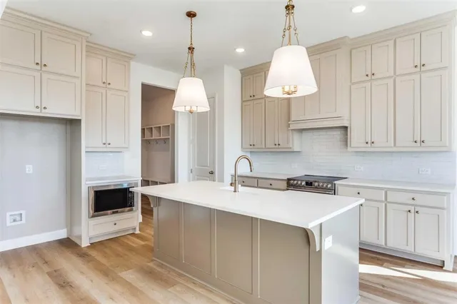 a kitchen with kitchen island granite countertop a stove a sink a center island and cabinets