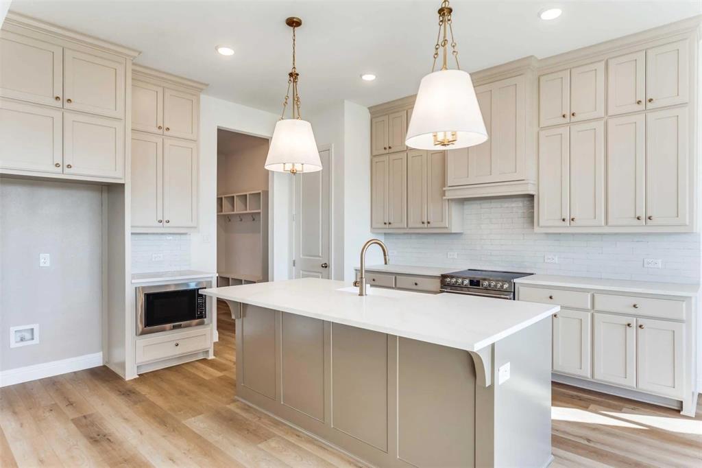 179 Galena Street Rhome, TX 76078 - Photo 3 of 17 a kitchen with kitchen island granite countertop a stove a sink a center island and cabinets
